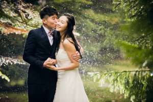 雨の中抱き合って立つ新郎新婦