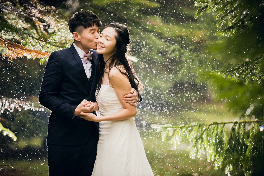 雨の中抱き合って立つ新郎新婦