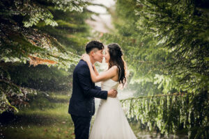 雨が降る森の中でキスをするカップル