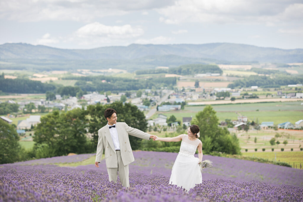 ラベンダー畑で手を繋いでいる新郎新婦