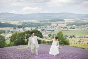 ラベンダー畑で手を繋いでいる新郎新婦