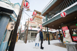 A couple standing in front of a retro shop near the Otaru Canal