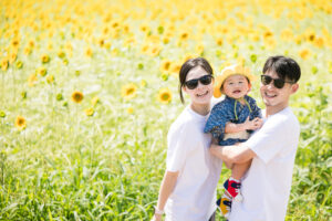 ひまわり畑の中で微笑む家族