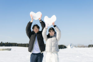 ハート形の雪を持つカップル