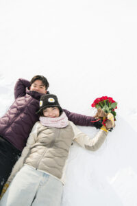 雪原で寝転ぶカップル