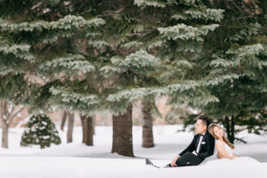 雪景色の中背中合わせに座っている新郎新婦