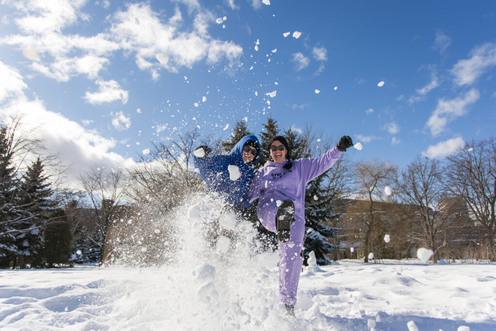 A couple kicking up the snow